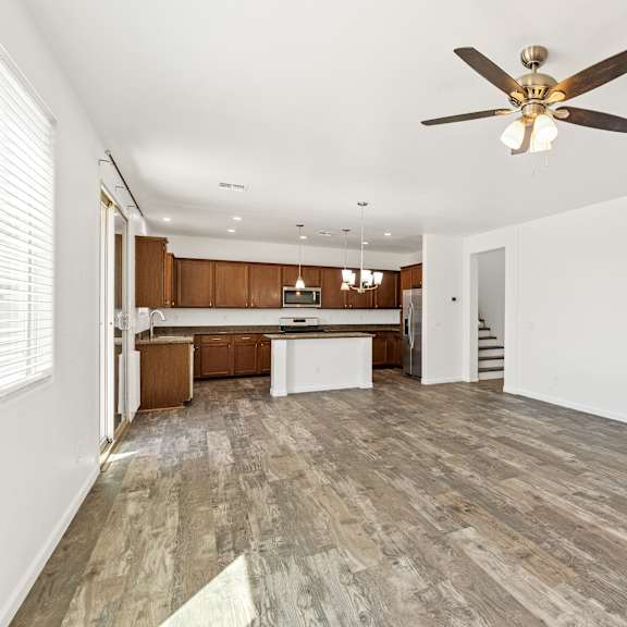 a room with a ceiling fan and wooden flooring.