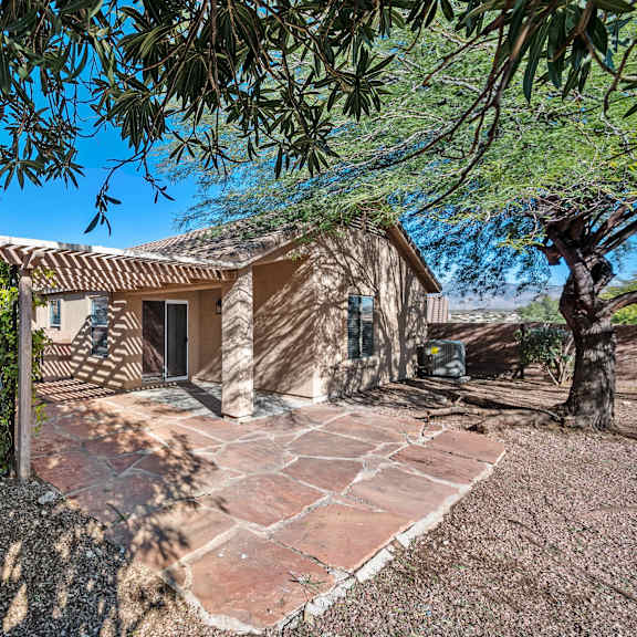 a small house with a driveway and a tree