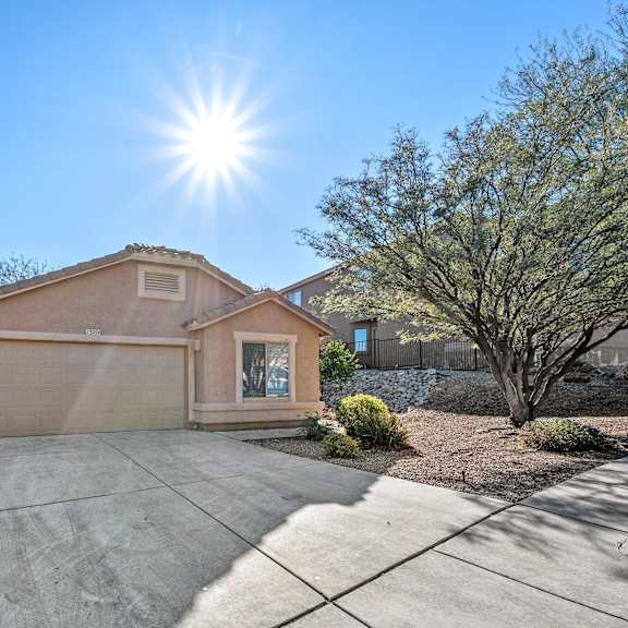 the front of a house with a sidewalk and a fence