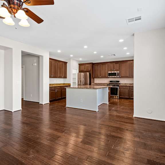 a spacious kitchen with brown cabinets and a white island.