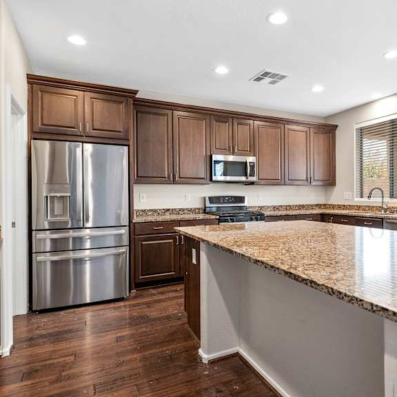 a kitchen with brown cabinets and granite countertops.