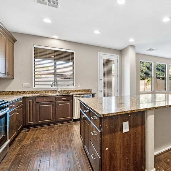 a kitchen with wooden cabinets and a marble countertop.