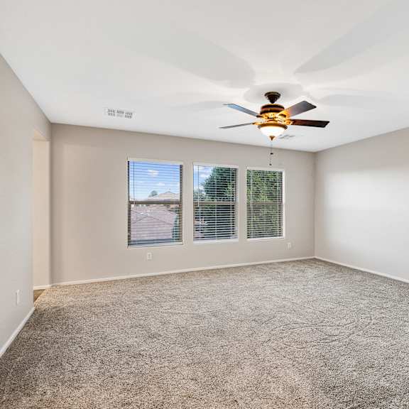 a room with a ceiling fan and carpeted floor.
