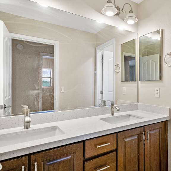 a white sink with a silver faucet and a mirror above it.
