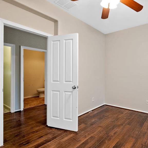 a room with a white door and a ceiling fan.