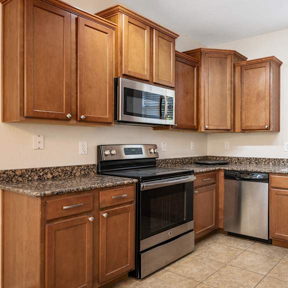 a kitchen with wooden cabinets and stainless steel appliances