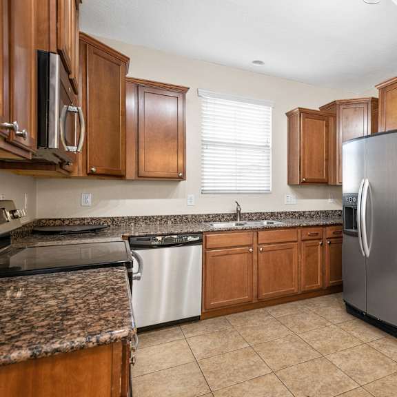 a kitchen with wooden cabinets and a stainless steel refrigerator