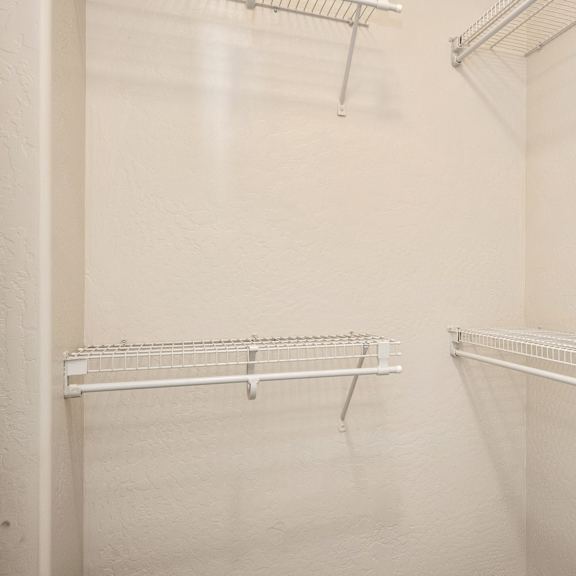 an empty closet with two hanging racks in it