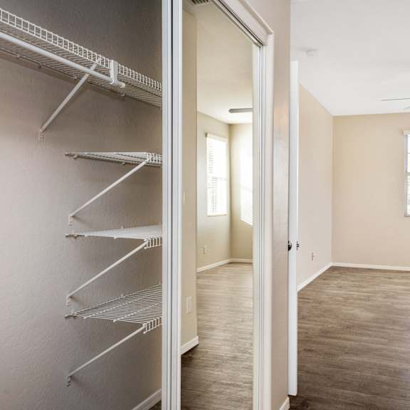 an empty closet with shelves and a ceiling fan
