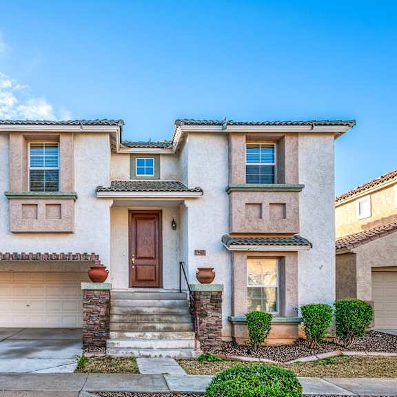 the front of a house with a driveway and a garage door