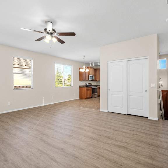 an empty room with a dance floor and a ceiling fan