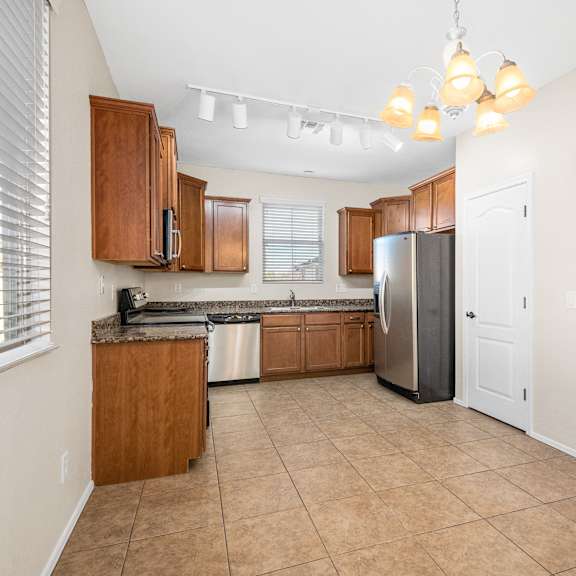 a kitchen with wooden cabinets and a stainless steel refrigerator