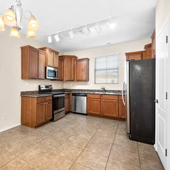 a kitchen with wooden cabinets and a black refrigerator