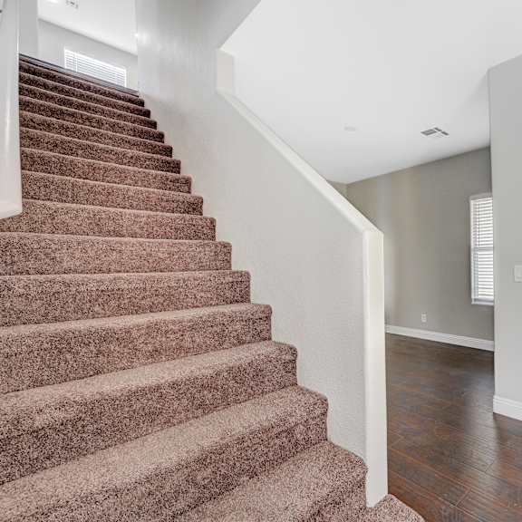 the entryway of a house with stairs and a white door