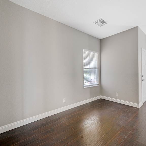 an empty living room with wood floors and a white door