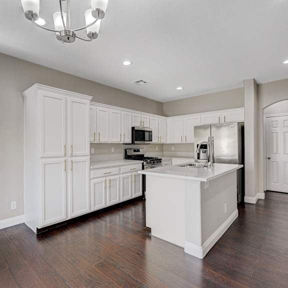 a kitchen with white cabinets and a white counter top