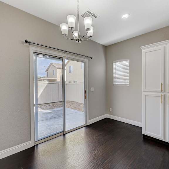 an empty living room with a sliding glass door to a patio