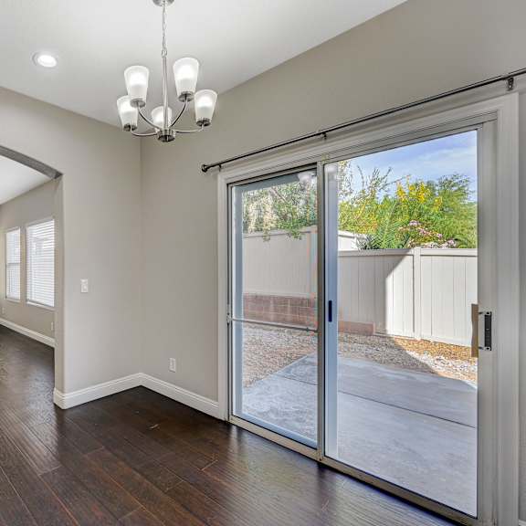 an empty living room with a sliding glass door to a patio