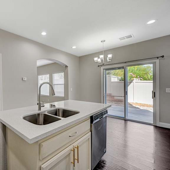 a kitchen with a sink and a door to a patio