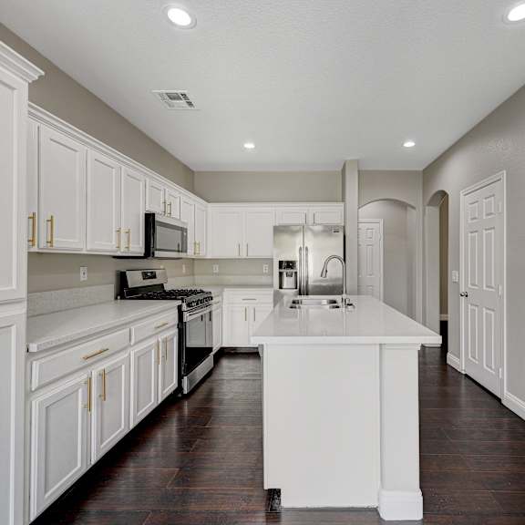a large kitchen with white cabinets and white counter tops