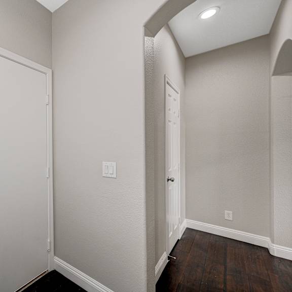 an empty room with white walls and a door to a closet