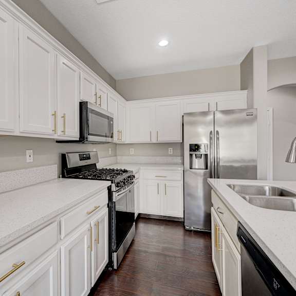 a kitchen with white cabinets and stainless steel appliances