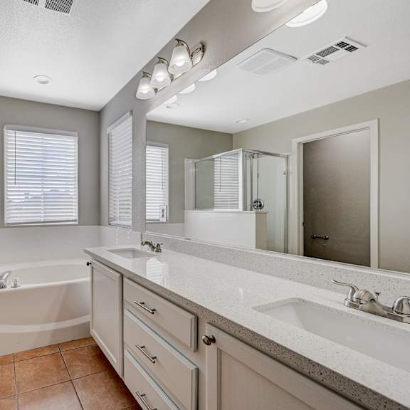 a bathroom with a large mirror and a tub and a shower