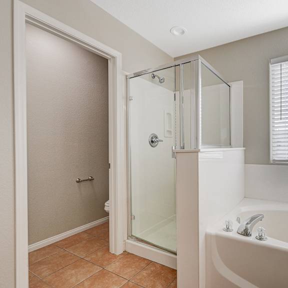 a bathroom with a tub and a shower and a sink