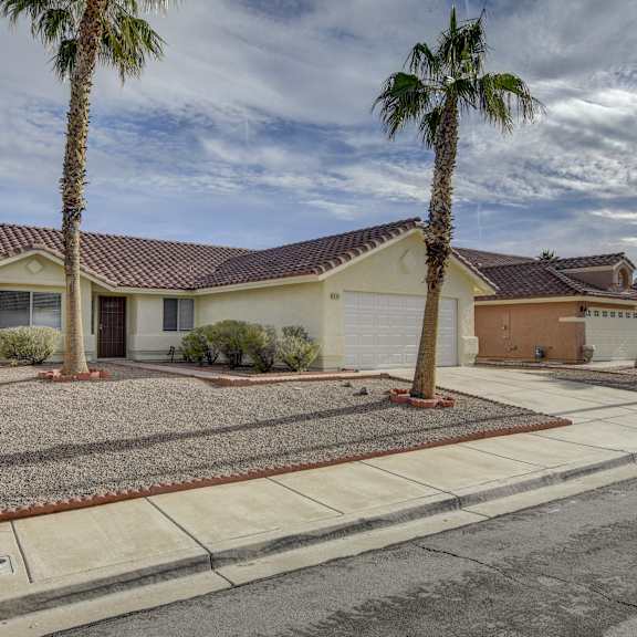 a house with a brown roof and a palm tree in front.