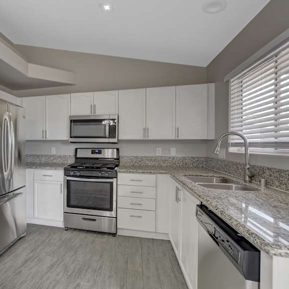 a kitchen with a refrigerator, oven, and microwave.
