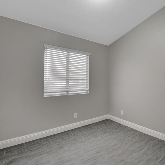 a room with a window and wooden flooring.