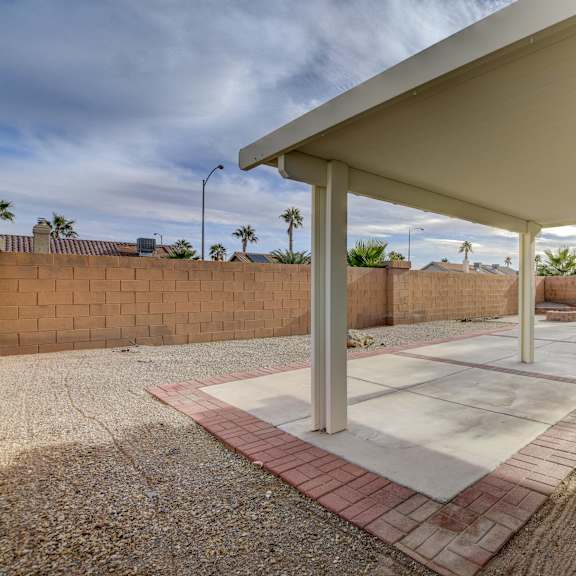 a patio with a white roof and red brick border.