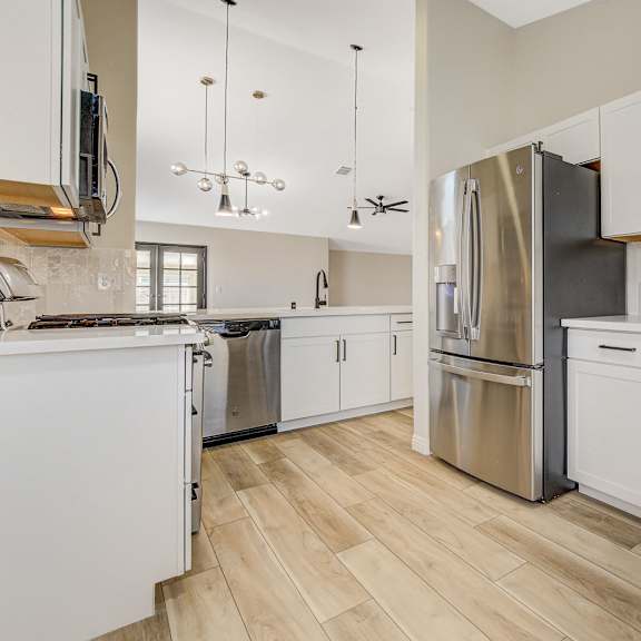 a kitchen with white cabinets and a black refrigerator.