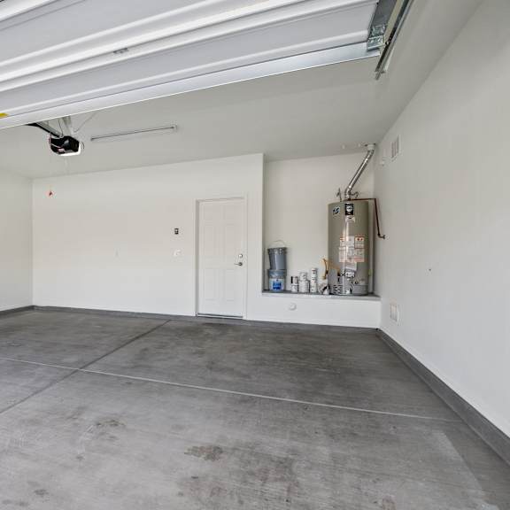 an empty garage with a concrete floor and white walls
