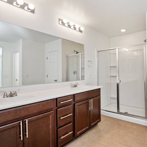 a bathroom with a shower and a sink and a mirror