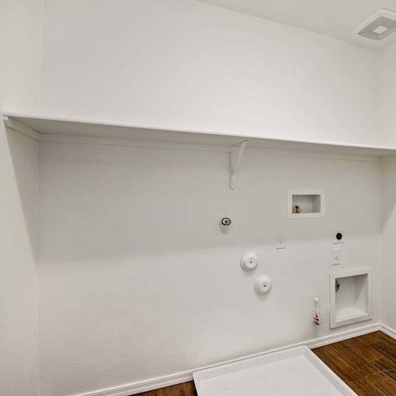the living room of an empty house with white walls and a wood floor