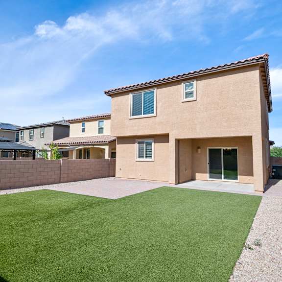 a yard in front of a house with a green lawn