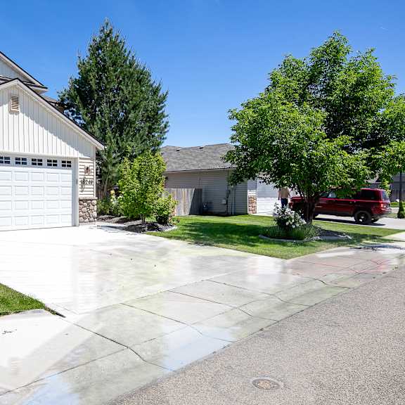 a white garage door is on the left side of the house.