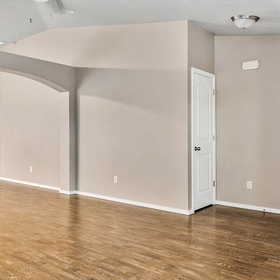 a room with wooden floors and white walls.