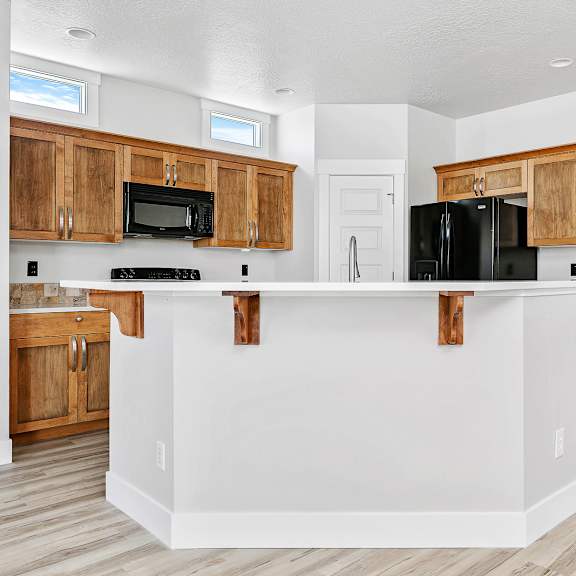a kitchen with wooden cabinets and black appliances.