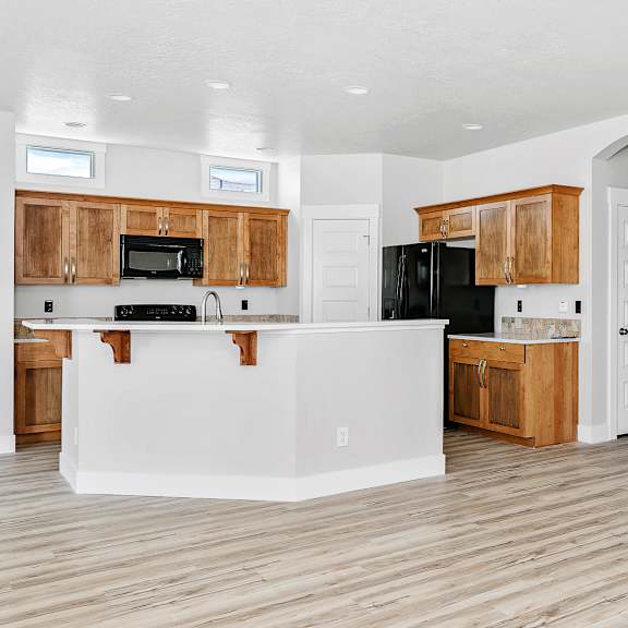 a kitchen with wooden cabinets and a white island.