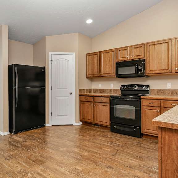 a kitchen with wooden cabinets and black appliances.