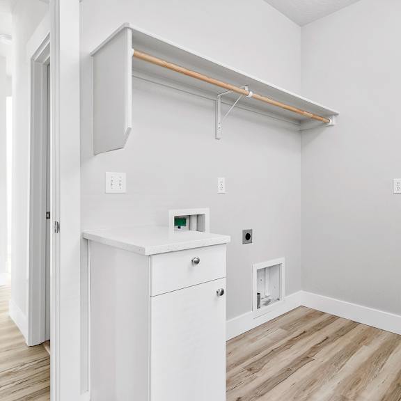 a white cabinet with a drawer is in a room with a wooden floor.