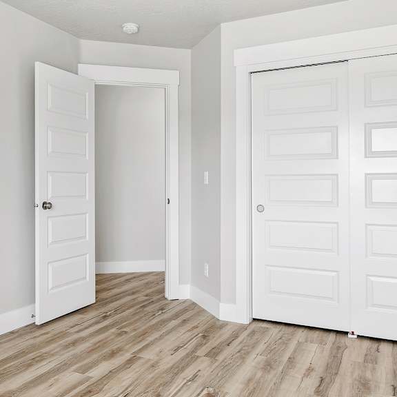 a room with two white doors, one of which is open.