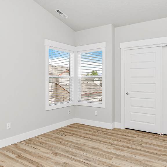 a room with a wooden floor and white walls.