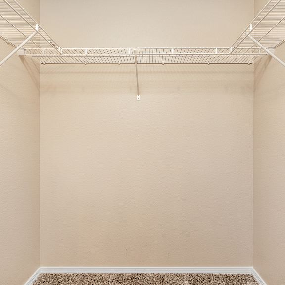 empty room with white shelves on the wall.
