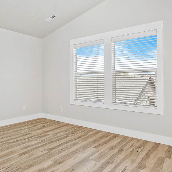 a room with a window and wooden flooring.