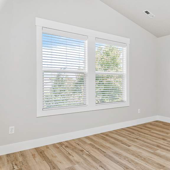 a room with a window and wooden flooring.