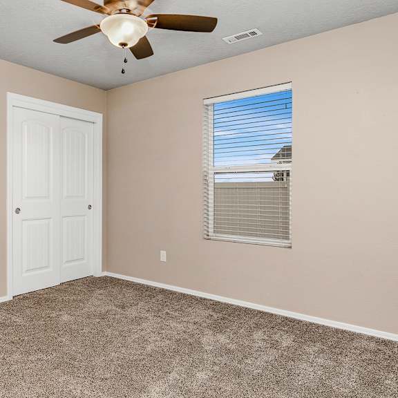 a room with a ceiling fan and a door.