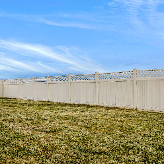 a long white fence runs along a grassy field.